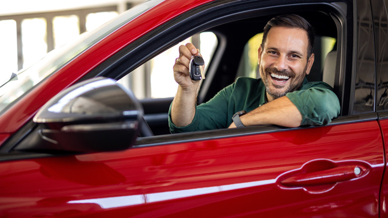 man in a brand new car