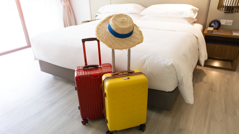 two suitcases next to a bed