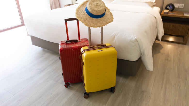 two suitcases next to a bed
