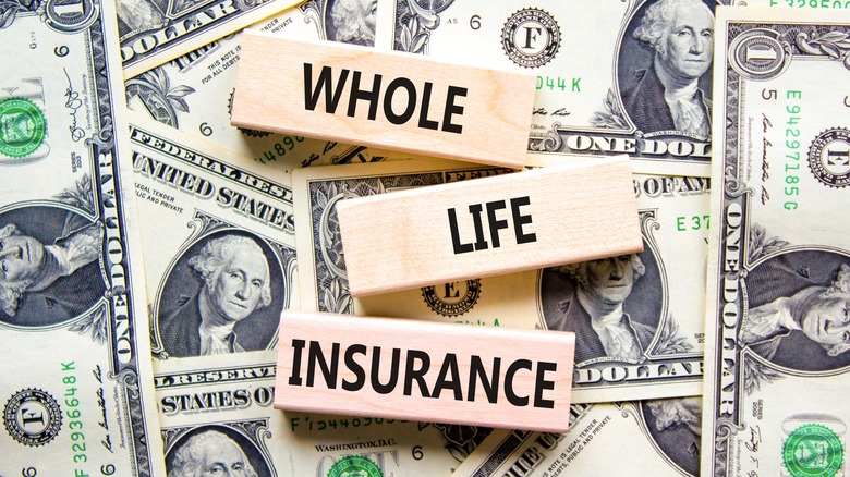 whole life insurance on blocks above dollar bills