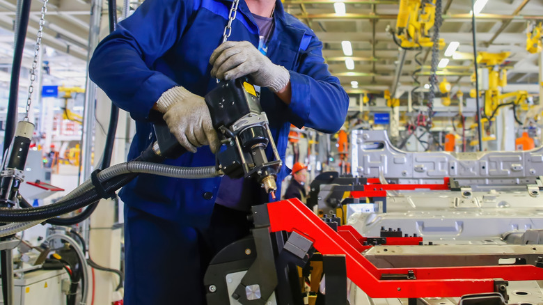Automotive worker handles equipment