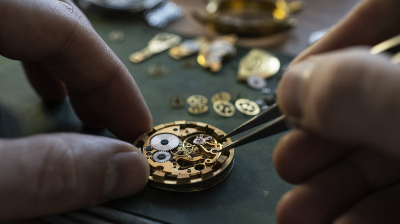 close up of man's hands as he repairs a watch