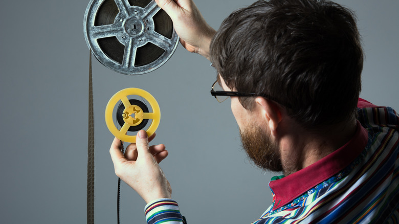 Bearded man holds large and small film reels