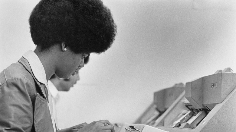Black and white photo of people operating punch card machines