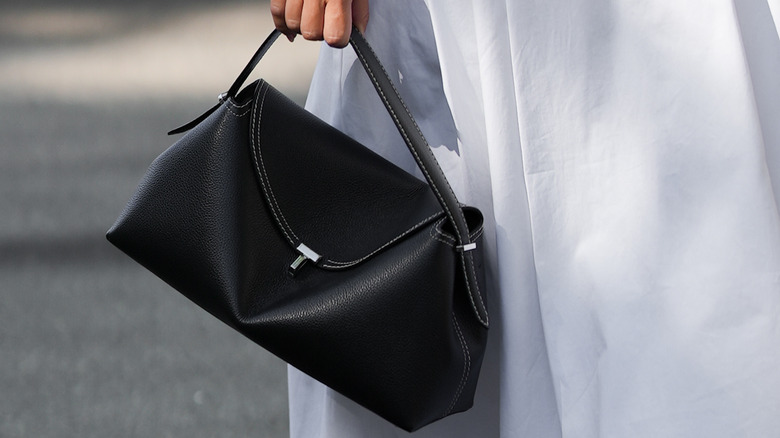 Stylish woman carrying Toteme T-Lock bag