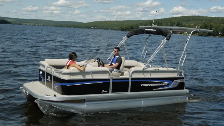 A couple sitting in a Princecraft Brio E 17  in the middle of a lake