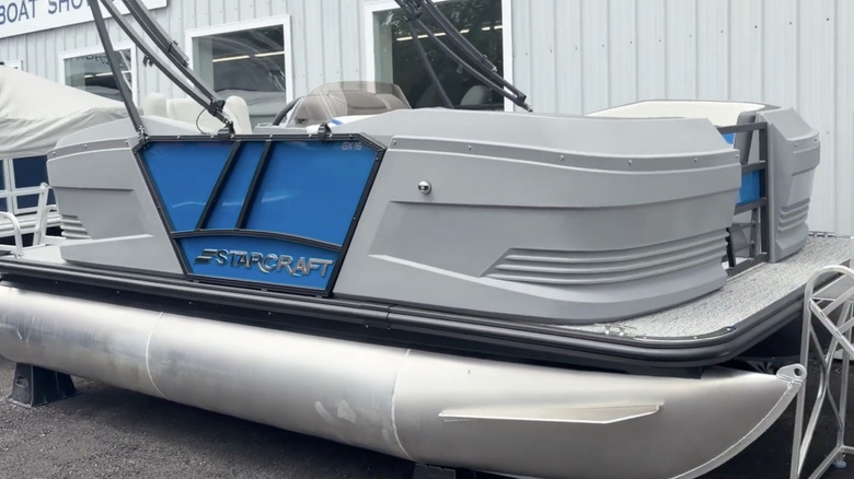 A Starcraft GX 16 R with blue panels on display outside of a dealership showroom