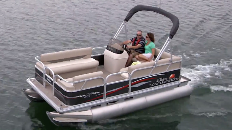 A couple riding in a Sun Tracker Party Barge 16 DLX