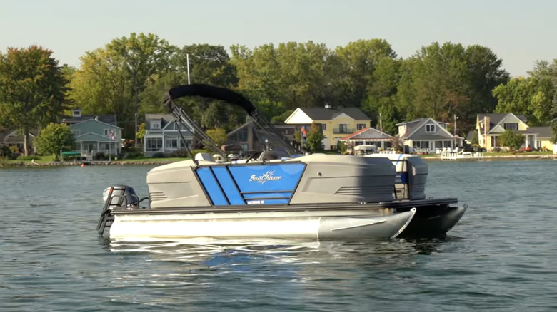 A SunChaser Lucerne 18 with blue panels floating on a lake