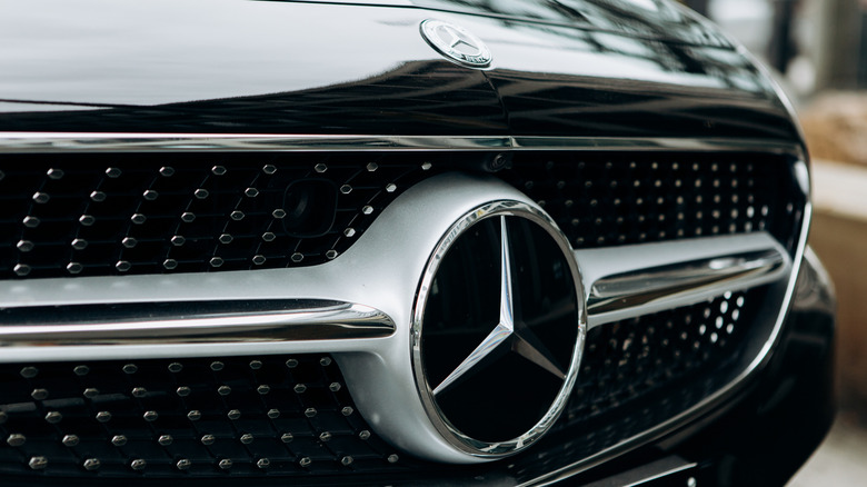 A close-up of the Mercedes Benz sign on the new black Mercedes-Benz SLC.