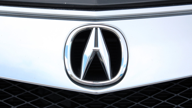 A closeup of the Acura MDX logo and emblem.