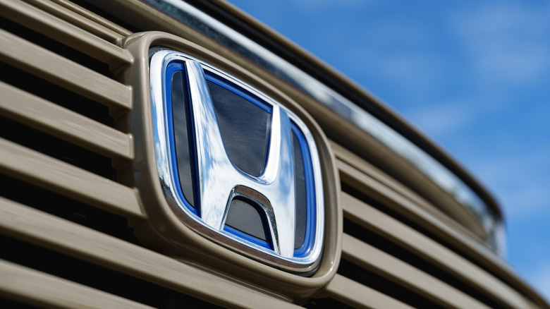 A Honda badge logo on the front of an SUV car .