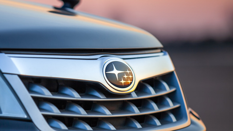 The Subaru grill with logo in front of sunset.