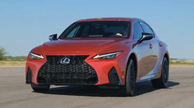 A red 2021 Lexus IS 350 F Sport driving around a track