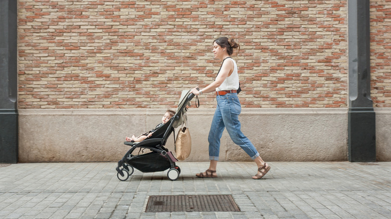 A young mother pushing a child in a stroller