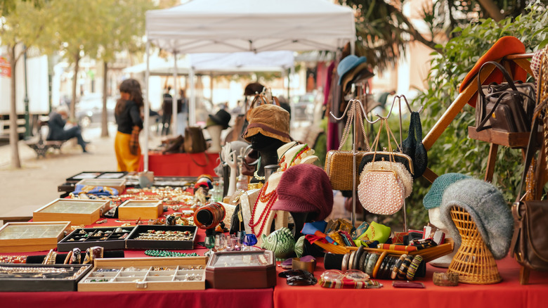 A table displaying clothes, jewelry, and knick knacks at a flea market