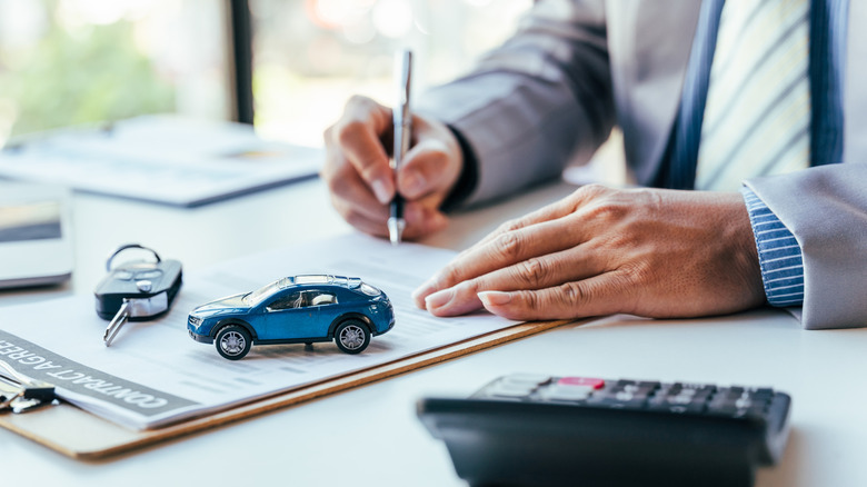 Man signing car insurance document or lease paper.