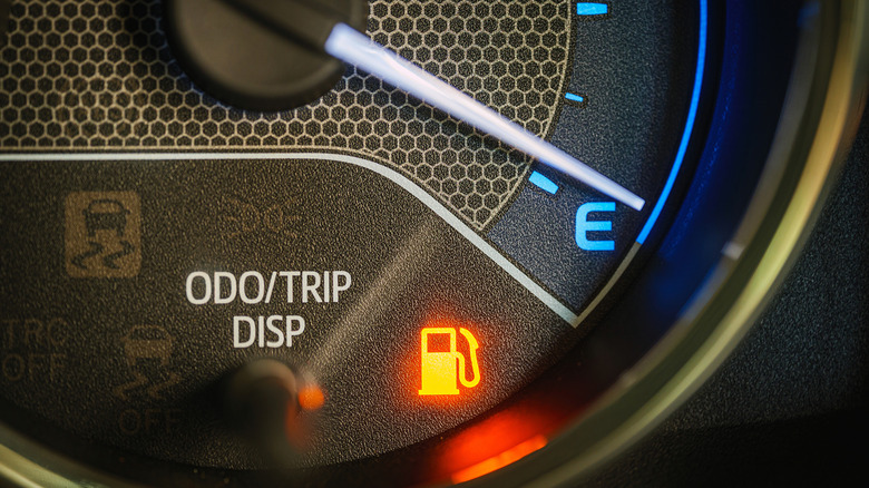 Low fuel warning light on car dashboard display
