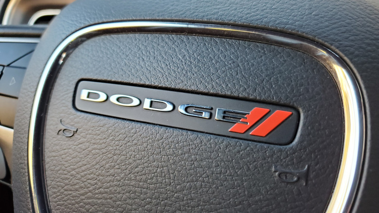 Close-up of a car steering wheel featuring the Dodge logo
