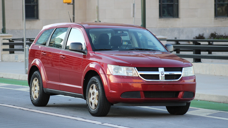 A burgundy Dodge Journey driving down the road.