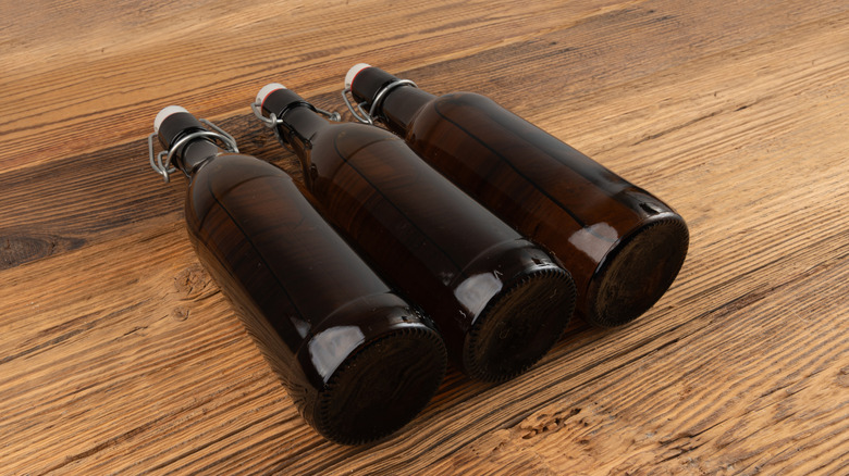 Three bottles of beer on a table.
