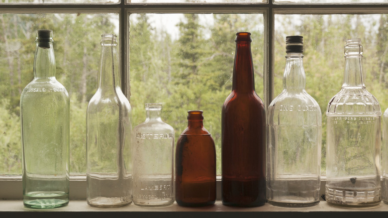A collection of antique glass bottles on windowsill