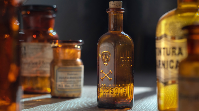 A vintage amber colored bottle of poison with a skull and crossbones engraved on it.