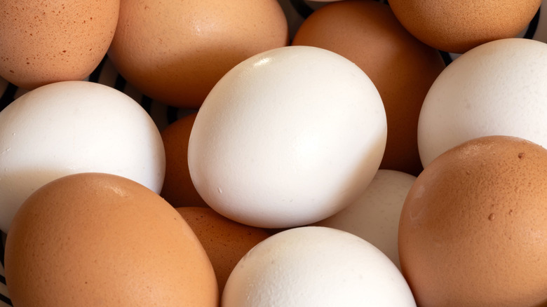 A pile of white and brown eggs
