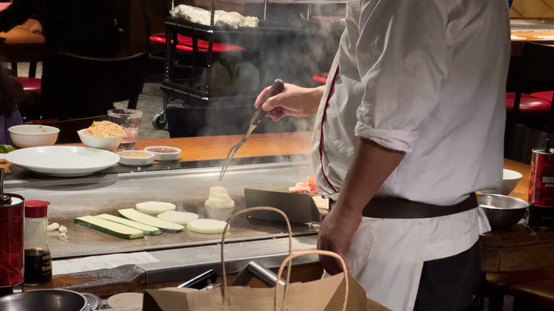 A chef frying vegetables at a Benihana location