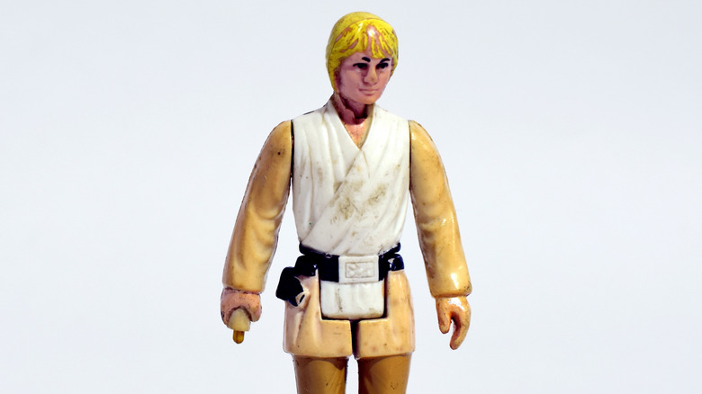 Vintage Luke Skywalker action figure standing against blank background