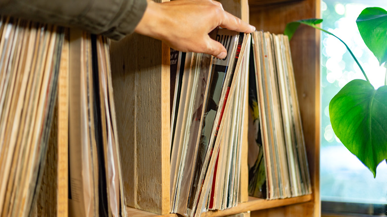 hand and a vinyl record collection