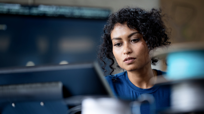 woman sitting at desk looking at computer