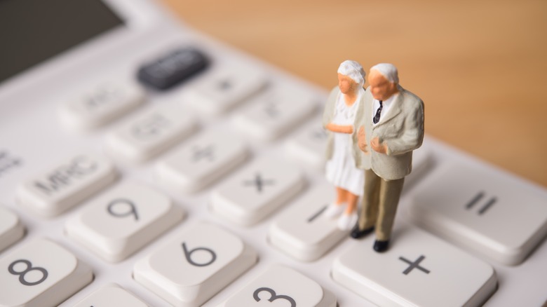 figurines of a senior couple on a calculator
