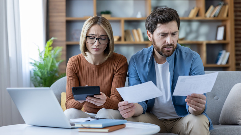 couple checking their bills in living room