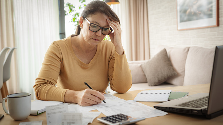 woman confused doing her finances at table