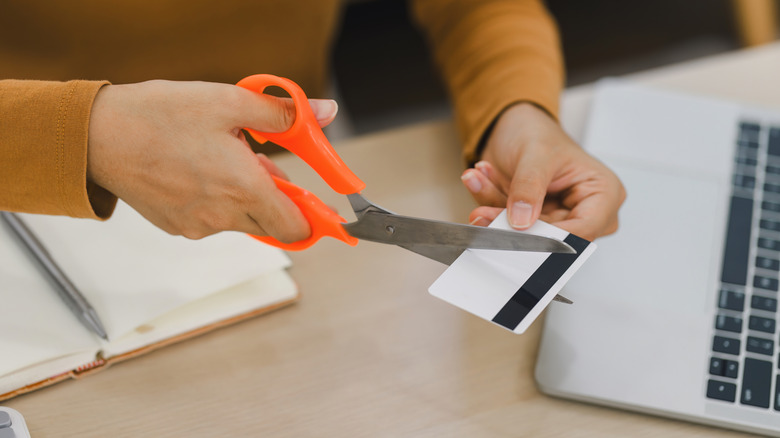 close-up of person cutting up credit card