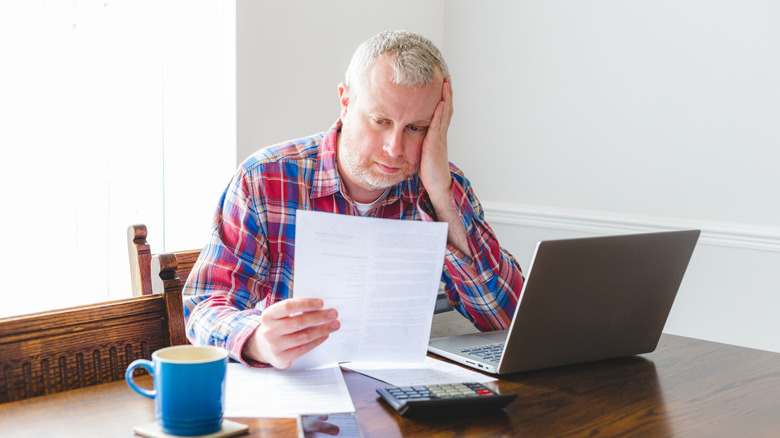 Senior man checking his energy bills at home.