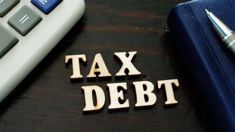 Wooden letters spelling 'tax debt'