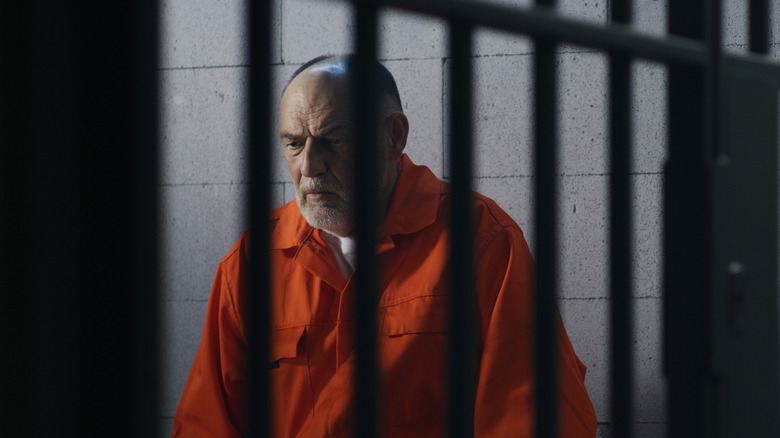 An elederly man in jail cell
