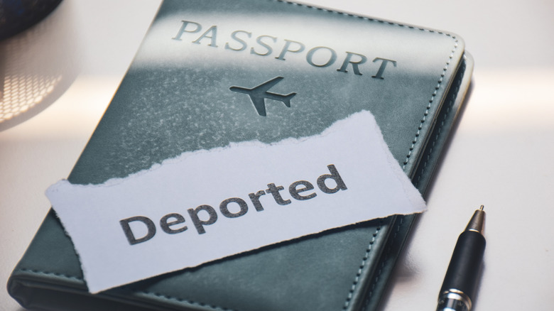 Passport booklet with sign saying 'deported'