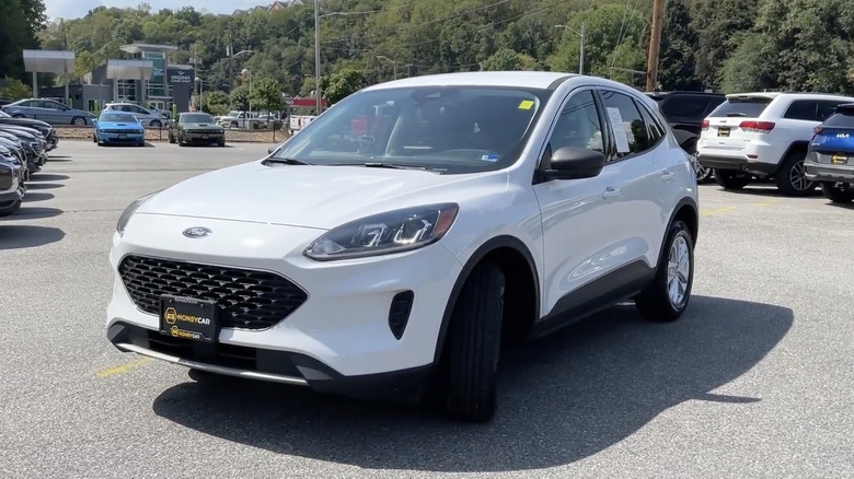 A white 2022 Ford Escape in a crowded dealership parking lot