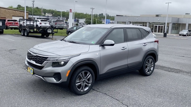 A silver 2022 Kia Seltos LX parked in a dealership parking lot on a cloudy day
