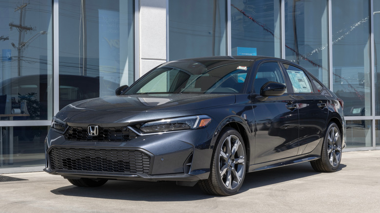 A Honda Civic Hybrid Sport Touring on display at a dealership.