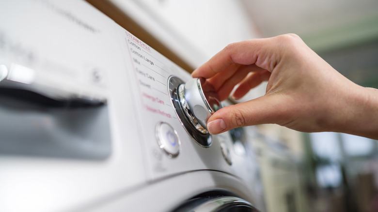 closeup of hand operating a washing machine