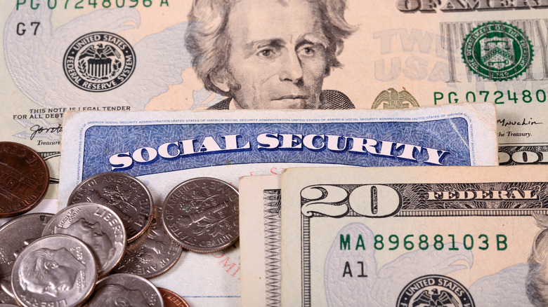 A Social Security card among US Treasury bills and coins.