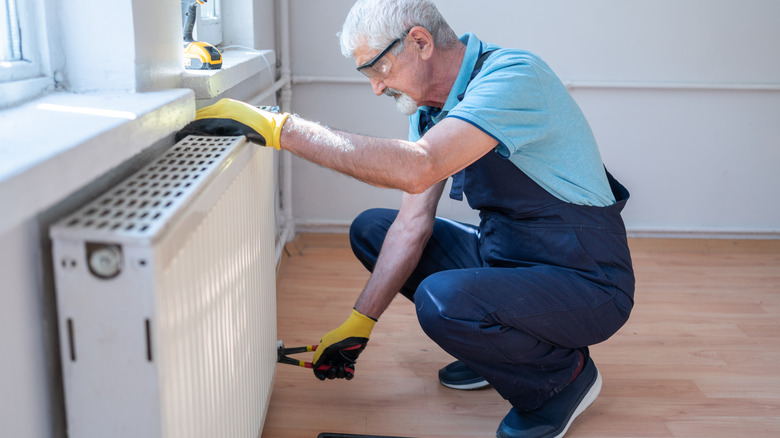 senior fixing a radiator