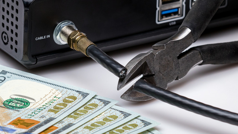 cutting a cord on a cable box cash in foreground