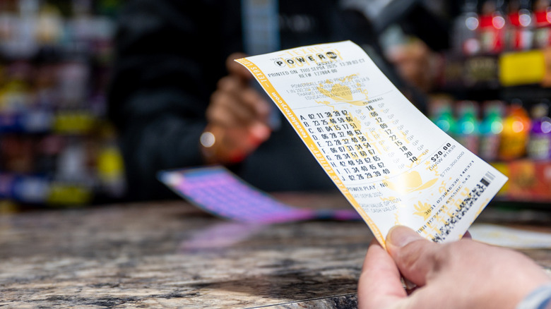 hand holding a lottery ticket