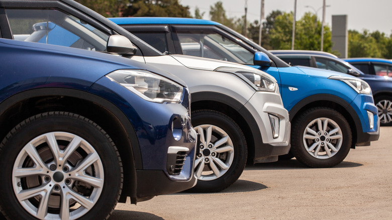 Side shot of multiple new cars on a dealership lot