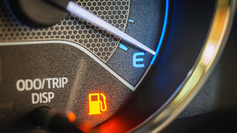 Close up of car fuel gage with pointer indicating near empty fuel tank